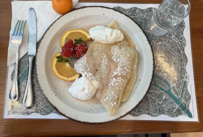 A bright and airy looking breakfast crepe with fruit on the side