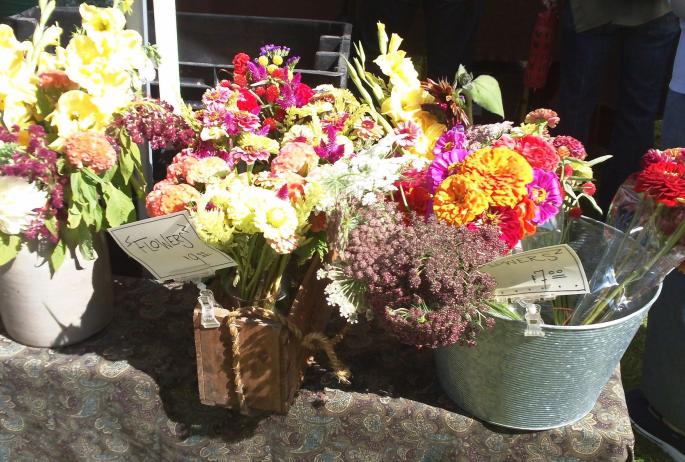 An array of cut flowers in metal buckets