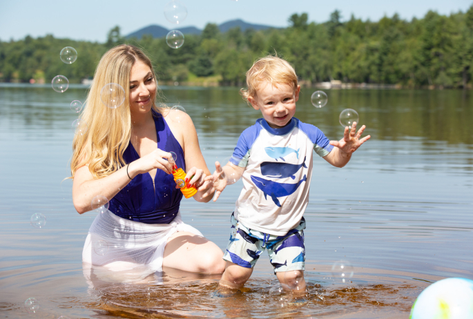 A mother and her child play in the water in Lake Clear