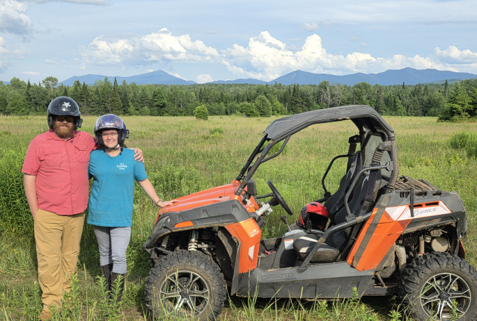 A couple standing next to a UTV.