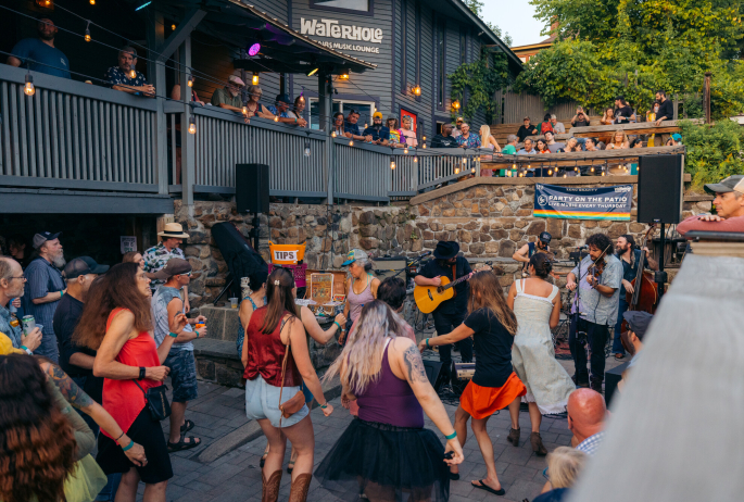 People dance and party at an outdoor venue of a restaurant.