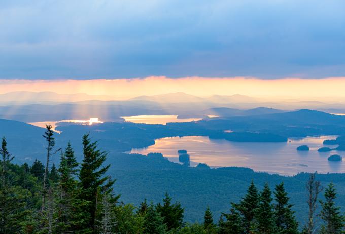 Stunning view of the reflection of the sunrise in a lake from the top of Ampersand Mountain