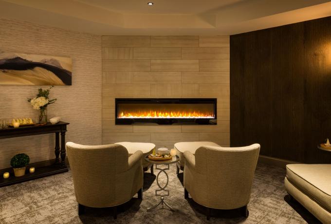 View of two chairs facing a floating gas fireplace at Ampersand Salon and Spa at Hotel Saranac