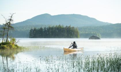 A paddler on a misty mountain lake