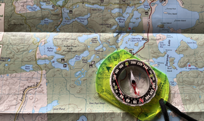 A map with a compass laying on top.