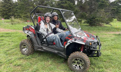 excited rider gives a thumbs up from inside the  Side-by-side