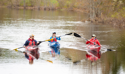 Three paddlers going down a river