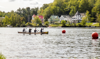 A team of four paddle a canoe down a river