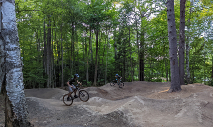 A kid jumps a dirt ramp on his bike