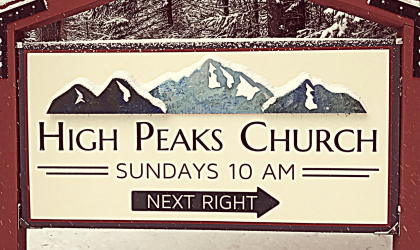 A sign for the entry to High Peaks Church blanketed in light snow